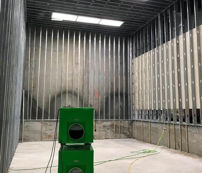 SERVPRO equipment setup in a room that has smoke damage on the walls and ceiling