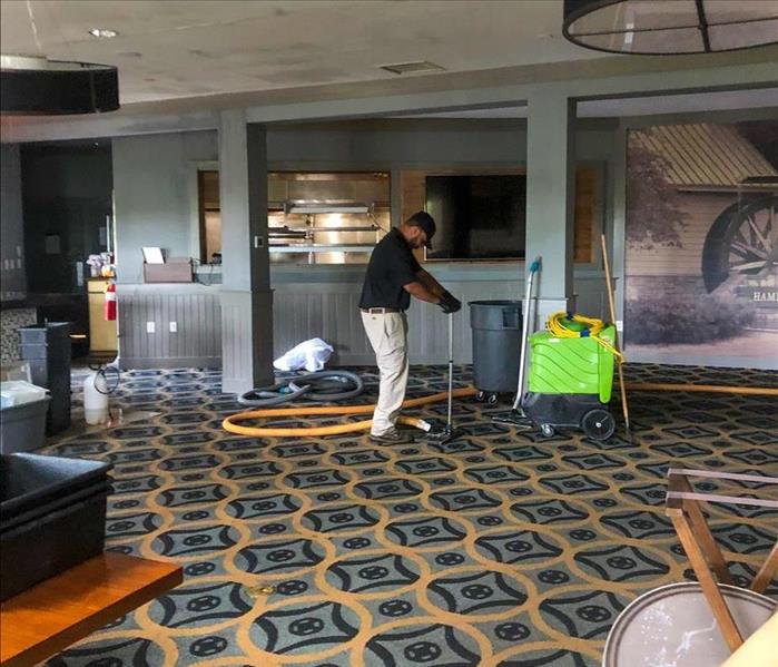 SERVPRO technician extracting water from the carpet of a Nashville business