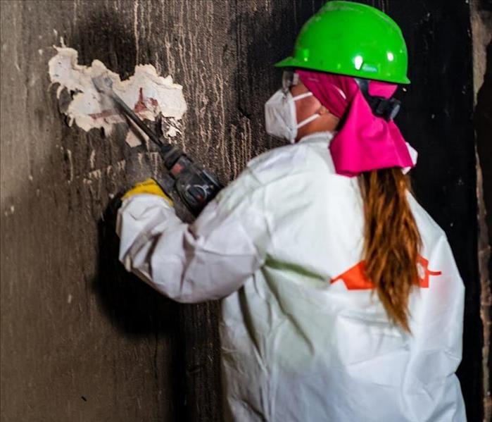 servpro employee in ppe cleaning fire damage