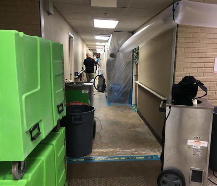 SERVPRO water damage restoration team at work in the hallway of a commercial restoration project