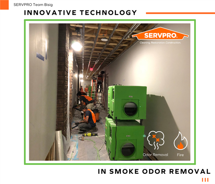 Image shows several SERVPRO fire damage restoration technicians at work cleaning up a commercial building