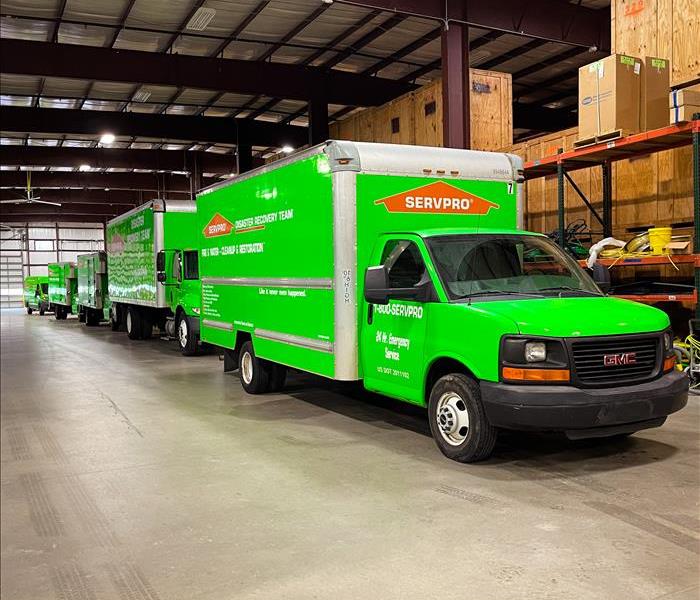 5 Green SERVPRO trucks in a warehouse in Nashville waiting to be dispatched to a water restoration project.